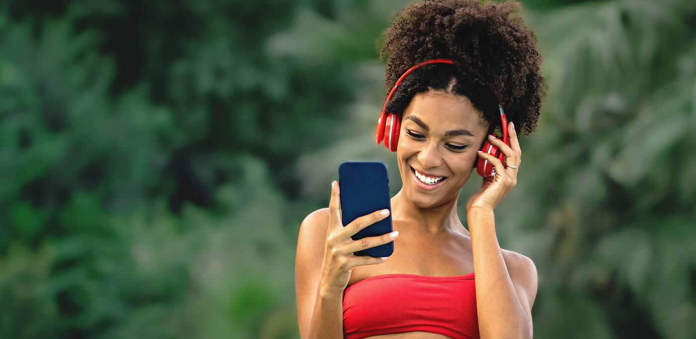 Women wearing headphones in red by the pool